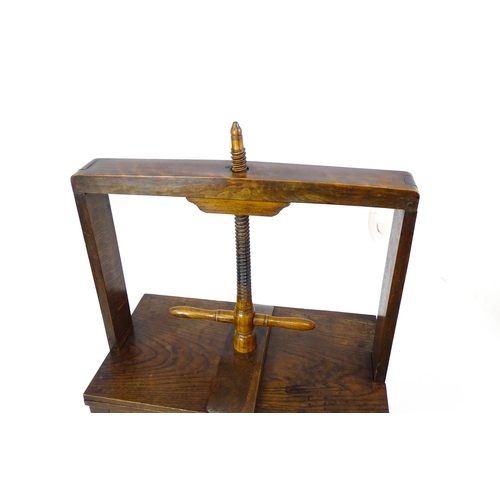 1451 - A late Georgian oak book press table, with screw system and turned handle above an adjustable press,... 