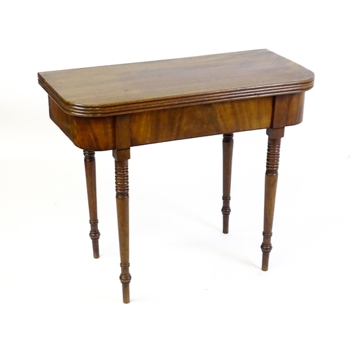 1453 - An early / mid 19thC mahogany card table, with a reeded edge above four turned tapering legs. 36