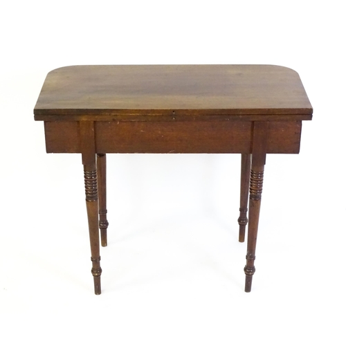 1453 - An early / mid 19thC mahogany card table, with a reeded edge above four turned tapering legs. 36