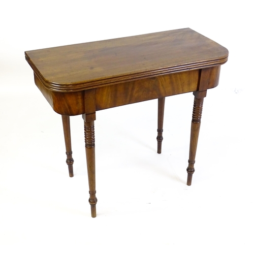 1453 - An early / mid 19thC mahogany card table, with a reeded edge above four turned tapering legs. 36