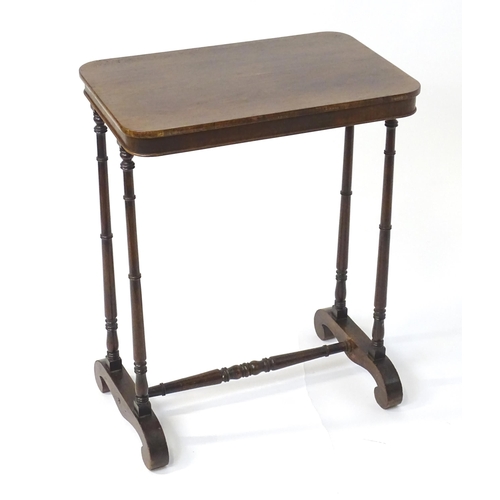 1454 - A mid 19thC rosewood side table, having an oblong top above four finely turned supports connected to... 