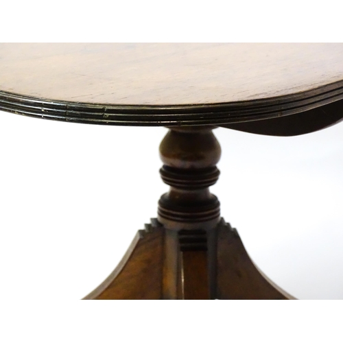 1456 - A 19thC rosewood dining table / breakfast table with a reeded tilt top above a turned pedestal and f... 