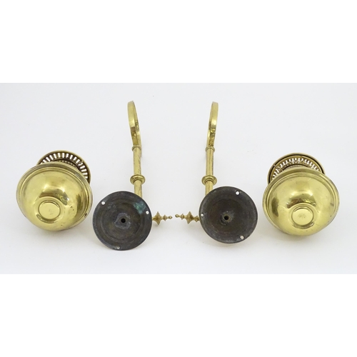 1313 - A pair of early 20thC oil lamps, the adjustable wall mounts supporting duplex burners, each approx 1... 