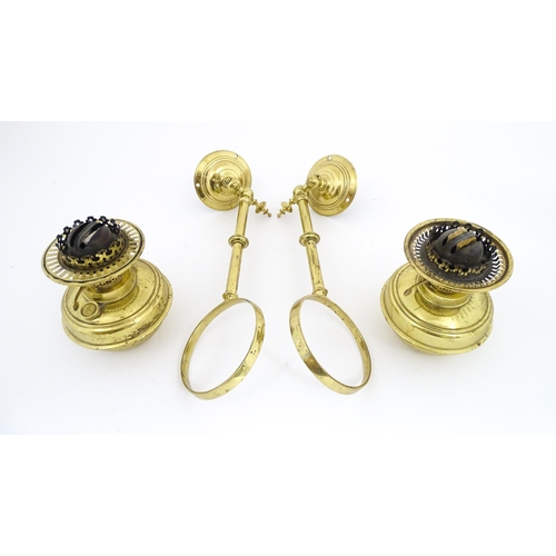 1313 - A pair of early 20thC oil lamps, the adjustable wall mounts supporting duplex burners, each approx 1... 