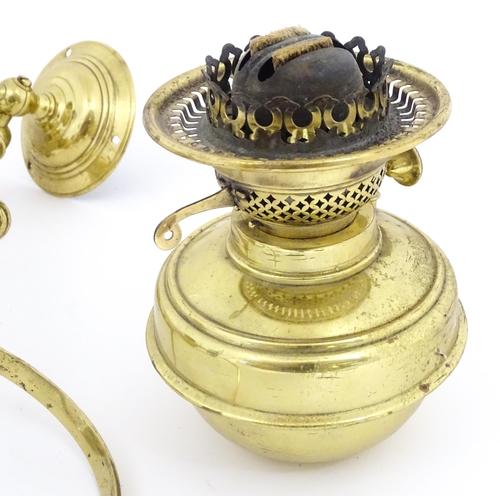 1313 - A pair of early 20thC oil lamps, the adjustable wall mounts supporting duplex burners, each approx 1... 