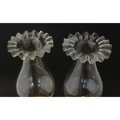 1315 - A pair of 19thC table oil lamps, the milk glass column bases with integral reservoirs, decorated wit... 