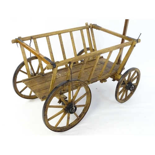 1321 - A 19thC wooden dog cart / hand cart with four wheels. Approx 47