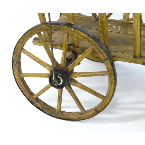 1321 - A 19thC wooden dog cart / hand cart with four wheels. Approx 47