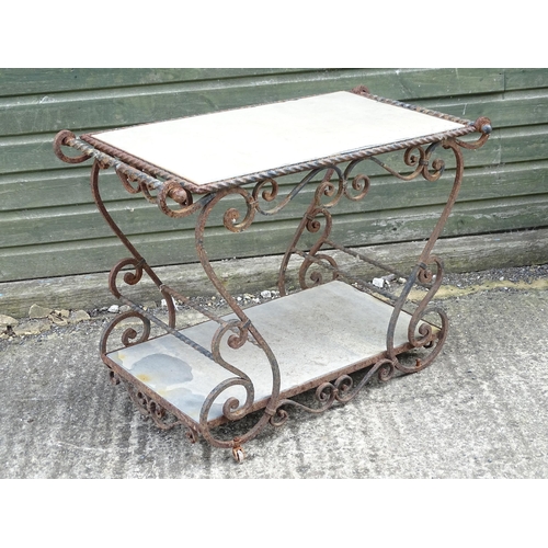 1323 - A mid 20thC wrought iron garden / patio table, the scrolled frame supporting two inset stone tiers, ... 