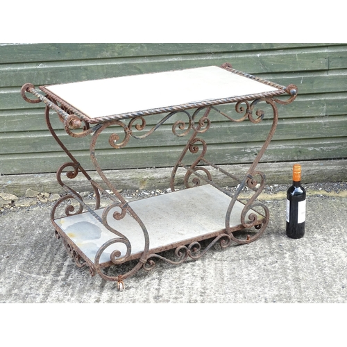 1323 - A mid 20thC wrought iron garden / patio table, the scrolled frame supporting two inset stone tiers, ... 