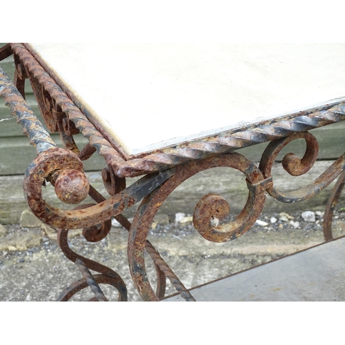 1323 - A mid 20thC wrought iron garden / patio table, the scrolled frame supporting two inset stone tiers, ... 