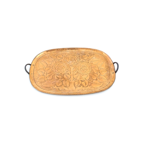 1011 - An Arts and Crafts style copper tray of oval form with twin handles and hammered and punchwork detai... 