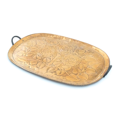 1011 - An Arts and Crafts style copper tray of oval form with twin handles and hammered and punchwork detai... 