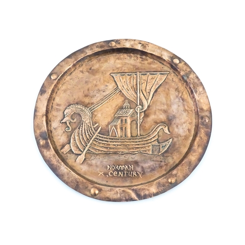 1012 - An Arts and Crafts copper charger with embossed decoration depicting a Viking ship titled under Norm... 