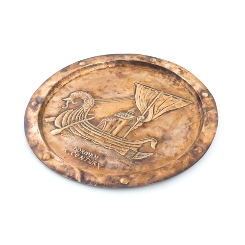 1012 - An Arts and Crafts copper charger with embossed decoration depicting a Viking ship titled under Norm... 