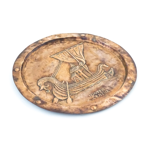 1012 - An Arts and Crafts copper charger with embossed decoration depicting a Viking ship titled under Norm... 