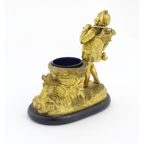 1014 - A late 19th / early 20thC gilt bronze figural spill vase modelled as a young man holding a basket of... 