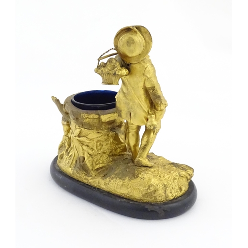 1014 - A late 19th / early 20thC gilt bronze figural spill vase modelled as a young man holding a basket of... 