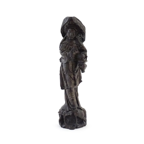 1025 - An Oriental carved hardwood figure with inlaid wirework detail, the carved naturalistic base with fi... 