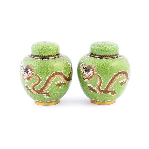 1027 - A pair of Oriental cloisonne ginger jars the green ground decorated with dragons and flaming pearl d... 