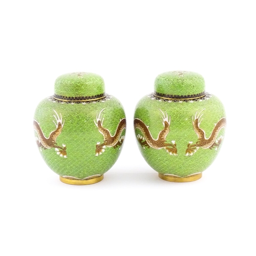 1027 - A pair of Oriental cloisonne ginger jars the green ground decorated with dragons and flaming pearl d... 