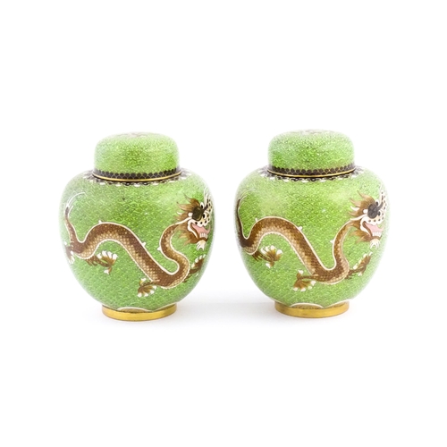 1027 - A pair of Oriental cloisonne ginger jars the green ground decorated with dragons and flaming pearl d... 