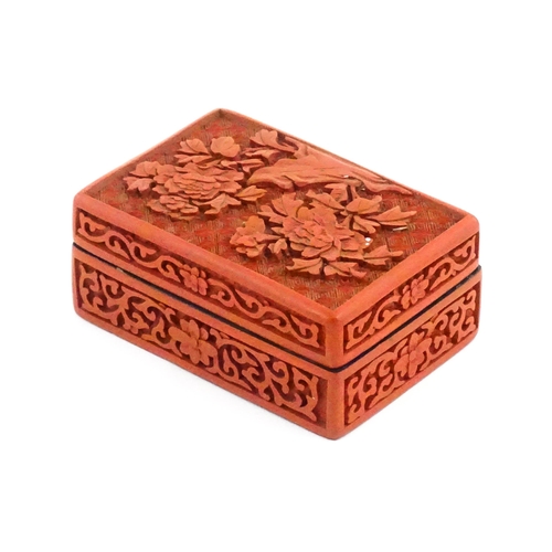 1036 - A Chinese cinnabar lacquer pot and cover of rectangular form, the lid decorated with peony flowers, ... 