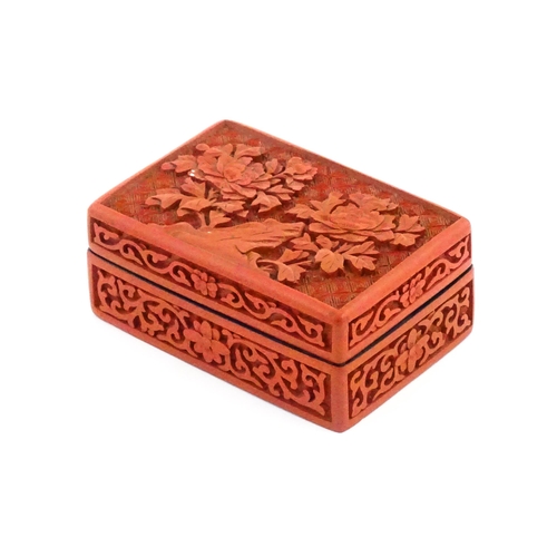 1036 - A Chinese cinnabar lacquer pot and cover of rectangular form, the lid decorated with peony flowers, ... 