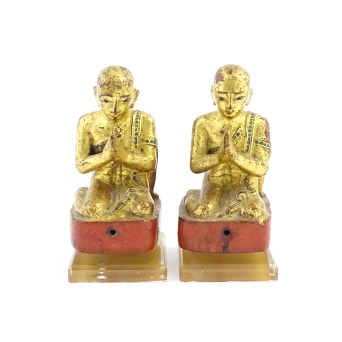 1041 - A pair of Asian carved wooden models of Buddhist monks in prayer with gilt detail. Approx. 8 1/4