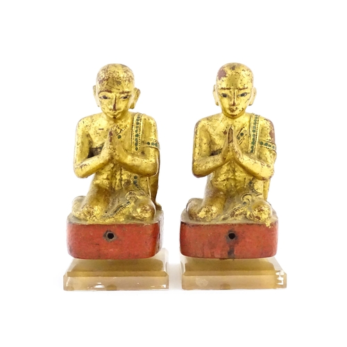 1041 - A pair of Asian carved wooden models of Buddhist monks in prayer with gilt detail. Approx. 8 1/4