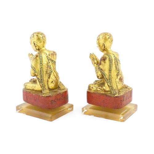 1041 - A pair of Asian carved wooden models of Buddhist monks in prayer with gilt detail. Approx. 8 1/4