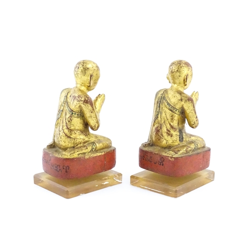 1041 - A pair of Asian carved wooden models of Buddhist monks in prayer with gilt detail. Approx. 8 1/4