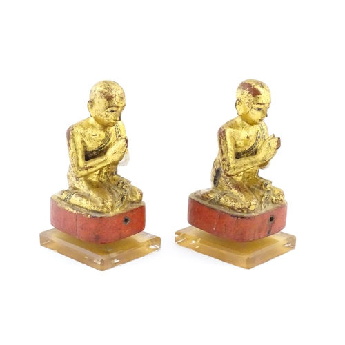 1041 - A pair of Asian carved wooden models of Buddhist monks in prayer with gilt detail. Approx. 8 1/4