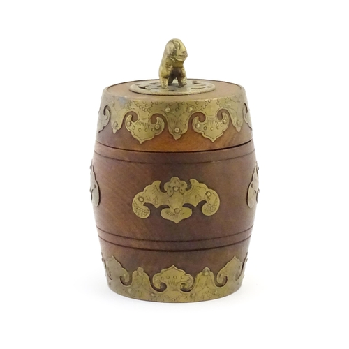 1047 - A Chinese tobacco jar of barrel form with stylised bat brass mounts and foo dog finial. Approx. 6 3/... 