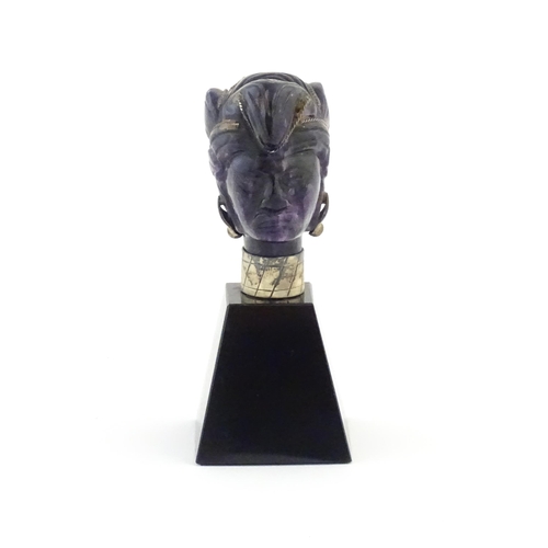 1048 - A 20thC amethyst carving modelled as a male head with headdress, mounted on a tapering plinth. Appro... 