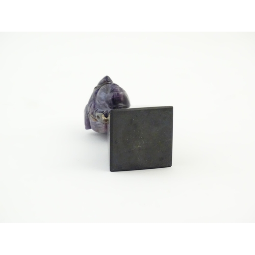 1048 - A 20thC amethyst carving modelled as a male head with headdress, mounted on a tapering plinth. Appro... 