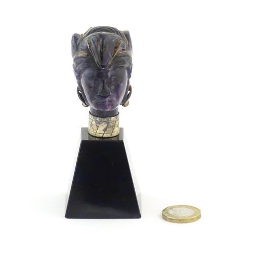 1048 - A 20thC amethyst carving modelled as a male head with headdress, mounted on a tapering plinth. Appro... 