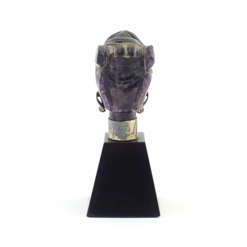 1048 - A 20thC amethyst carving modelled as a male head with headdress, mounted on a tapering plinth. Appro... 