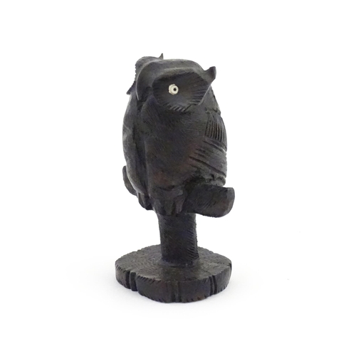 1057 - An early 20thC carved wooden model of an owl on a perch. Approx. 4 1/4