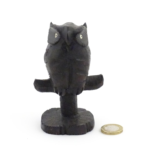 1057 - An early 20thC carved wooden model of an owl on a perch. Approx. 4 1/4