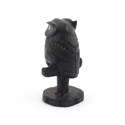 1057 - An early 20thC carved wooden model of an owl on a perch. Approx. 4 1/4