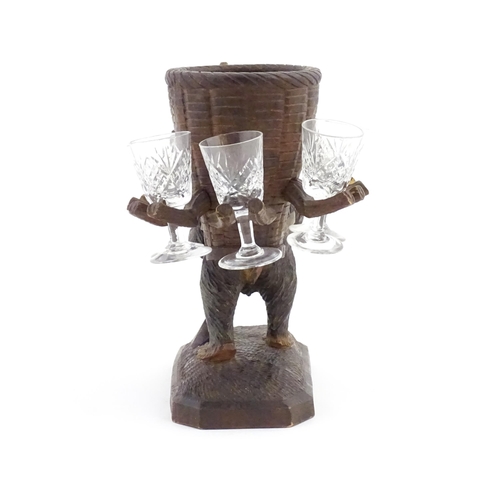 1058 - A 20thC Black Forest stand / holder, modelled as a carved hiking bear with a large basket on its bac... 