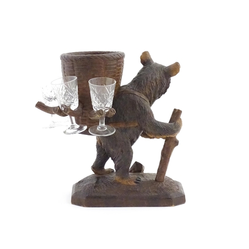 1058 - A 20thC Black Forest stand / holder, modelled as a carved hiking bear with a large basket on its bac... 