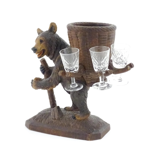 1058 - A 20thC Black Forest stand / holder, modelled as a carved hiking bear with a large basket on its bac... 