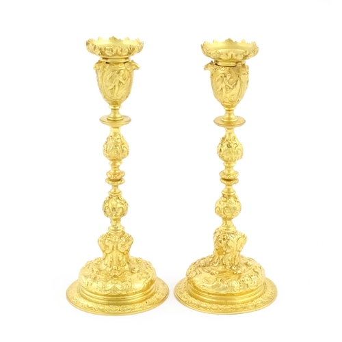 1068 - A pair of 19thC Continental ormolu candlesticks with relief figural and animal detail. Approx. 9