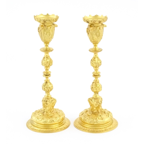 1068 - A pair of 19thC Continental ormolu candlesticks with relief figural and animal detail. Approx. 9