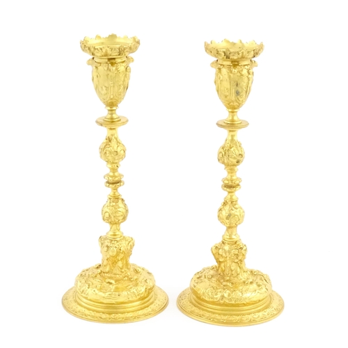 1068 - A pair of 19thC Continental ormolu candlesticks with relief figural and animal detail. Approx. 9