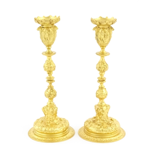 1068 - A pair of 19thC Continental ormolu candlesticks with relief figural and animal detail. Approx. 9