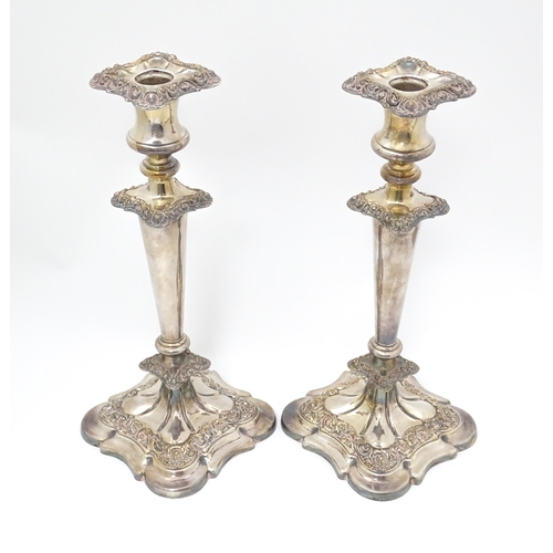 609 - A pair of silver plate candlesticks with floral and acanthus scroll decoration. 12 1/2