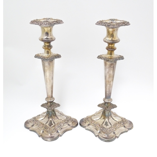 609 - A pair of silver plate candlesticks with floral and acanthus scroll decoration. 12 1/2